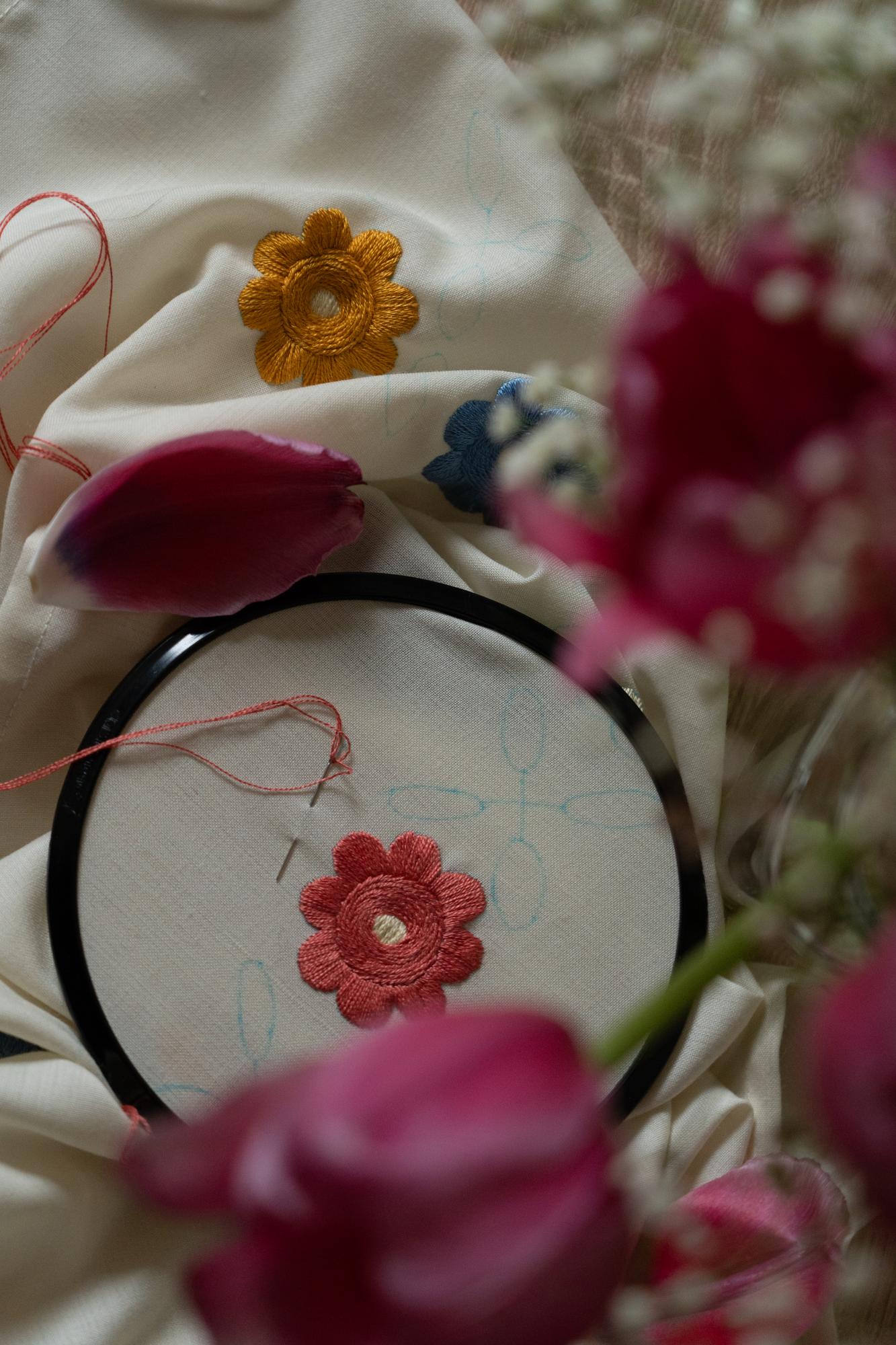 Dettaglio mano che ricama un fiore